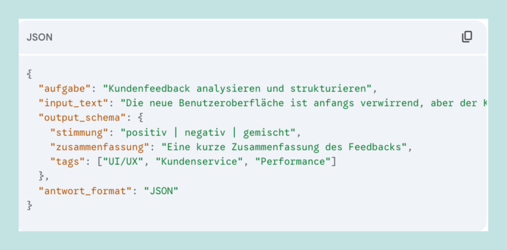 JSON-Code mit Aufgabe 'Kundenfeedback analysieren und strukturieren', Eingabetext zur Benutzeroberfläche, Ausgabe-Schema mit Stimmung, Zusammenfassung und Tags, Antwortformat JSON